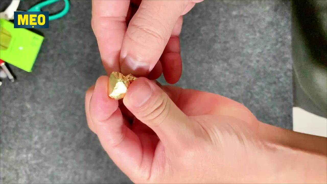 Miếng giấy bạc được gấp tròn và nhét vào khe hở của pin AAA để làm đầy khoảng trống.