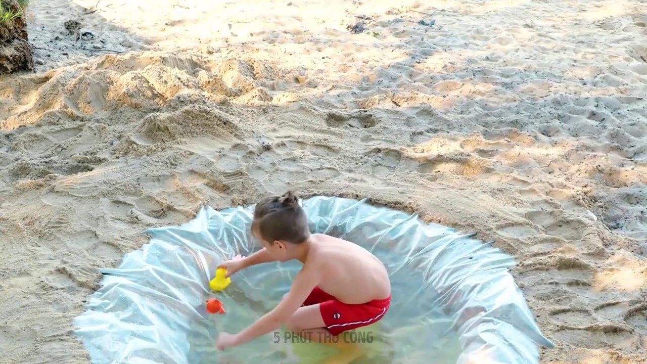 Một cô gái trẻ nằm trong lều màu cam, đeo đèn pin đọc sách giữa không gian ấm cúng với gối và đèn chiếu sáng.