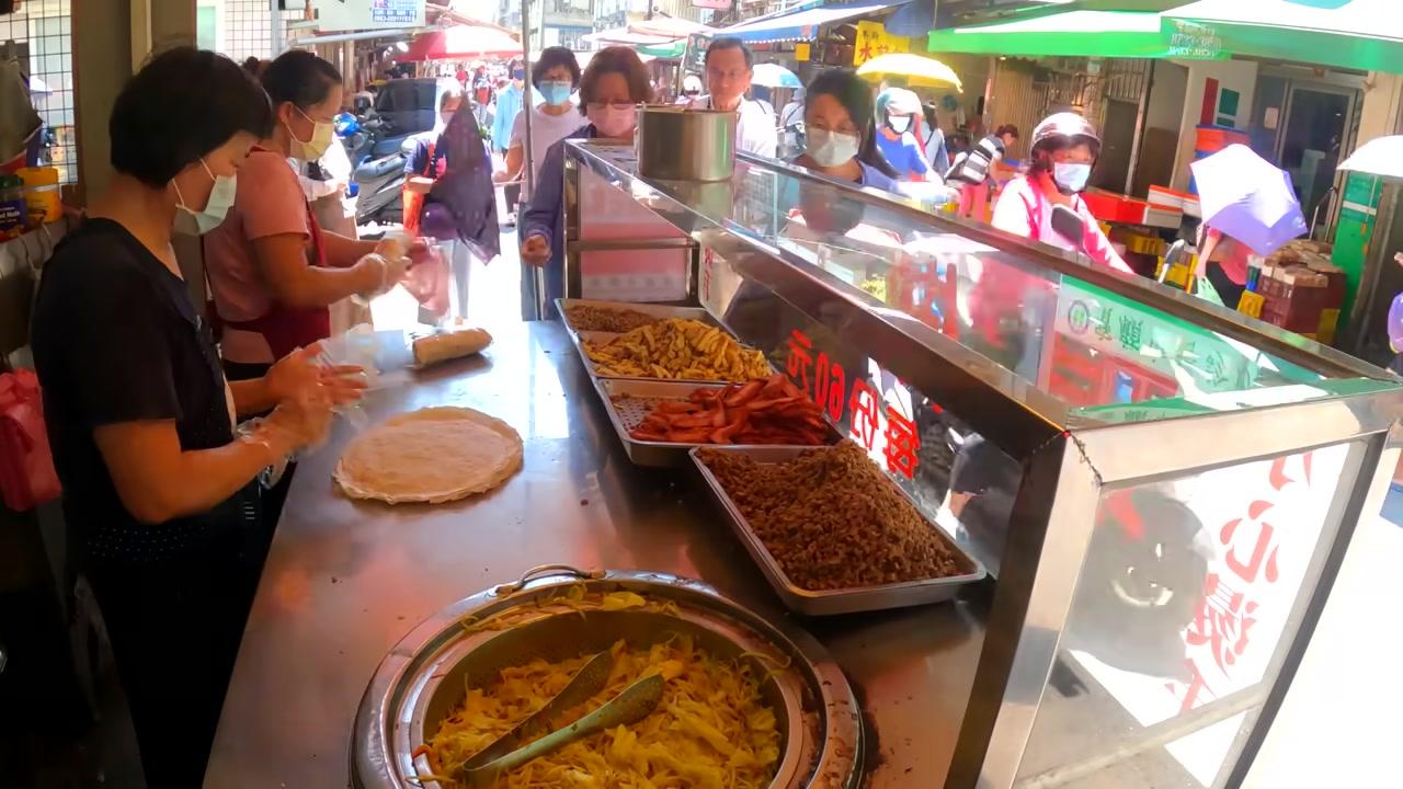 Một góc chợ đêm nhộn nhịp với vô số quầy thức ăn hấp dẫn và ánh đèn rực rỡ.