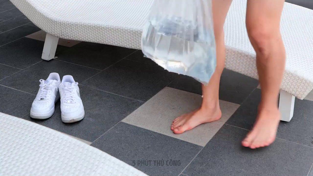 Một du khách đang sắp xếp quần áo trên giá treo ngoài ban công, tận dụng ánh nắng và gió trời.