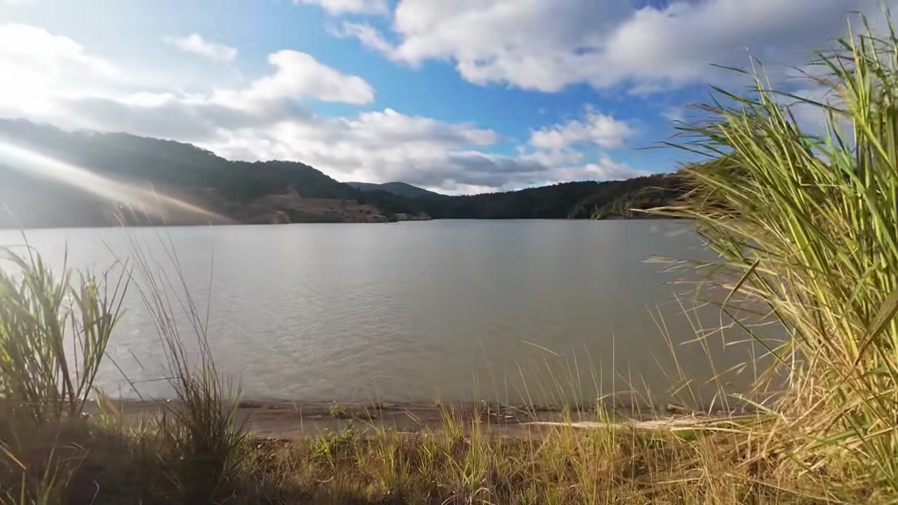 Toàn cảnh hồ thủy điện Thượng Kon Tum với mặt nước xanh biếc in bóng mây trời và rừng cây.