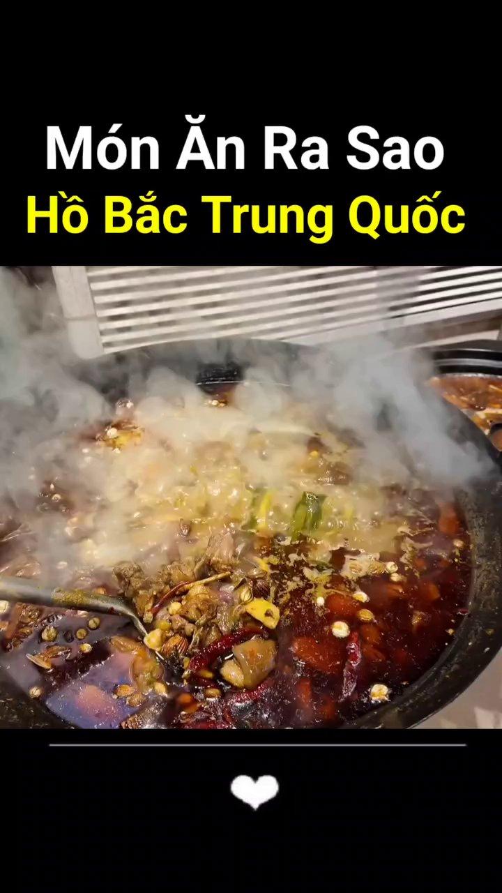 Nồi nước dùng lớn đang sôi sùng sục trên bếp, bên trong là các loại gia vị như thảo quả, hồi và ớt.