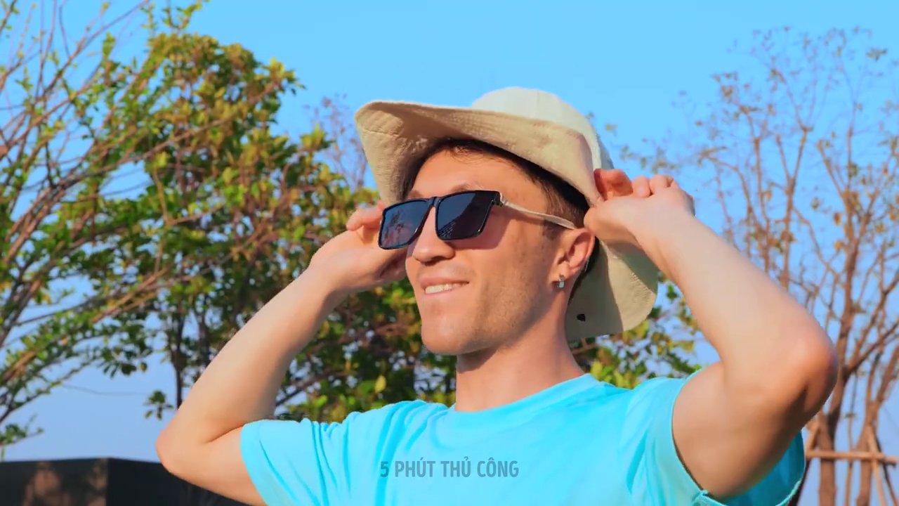 Một bàn tay đang thử nghiệm một thiết bị thủ công tự chế từ chai nhựa và dây kim loại trong làn nước.
