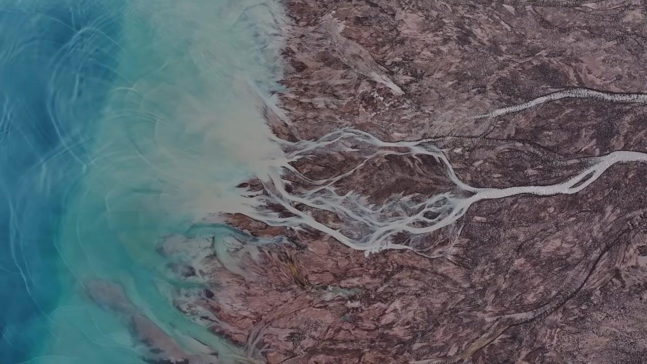 Góc nhìn từ drone cho thấy những dòng nước xanh ngọc với hoa văn xoáy do trầm tích băng tan tạo nên.