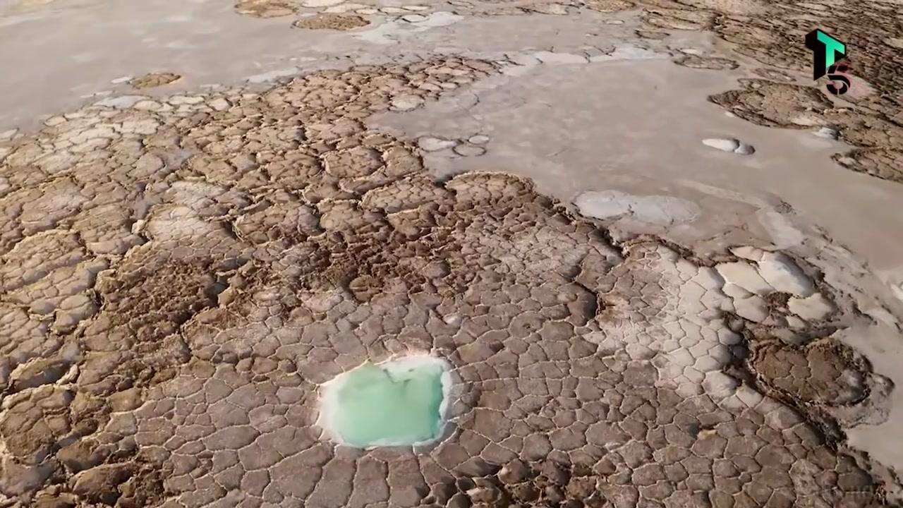 Cận cảnh suối nước nóng với các vòng tròn màu sắc rực rỡ từ đỏ cam ở rìa ngoài đến xanh lam ở trung tâm.