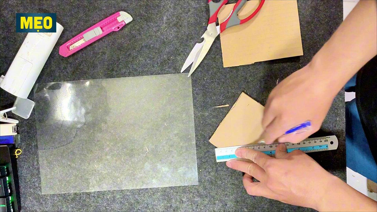 Các miếng bìa carton và nhựa trong suốt được cắt và ghép lại thành hình kim tự tháp.