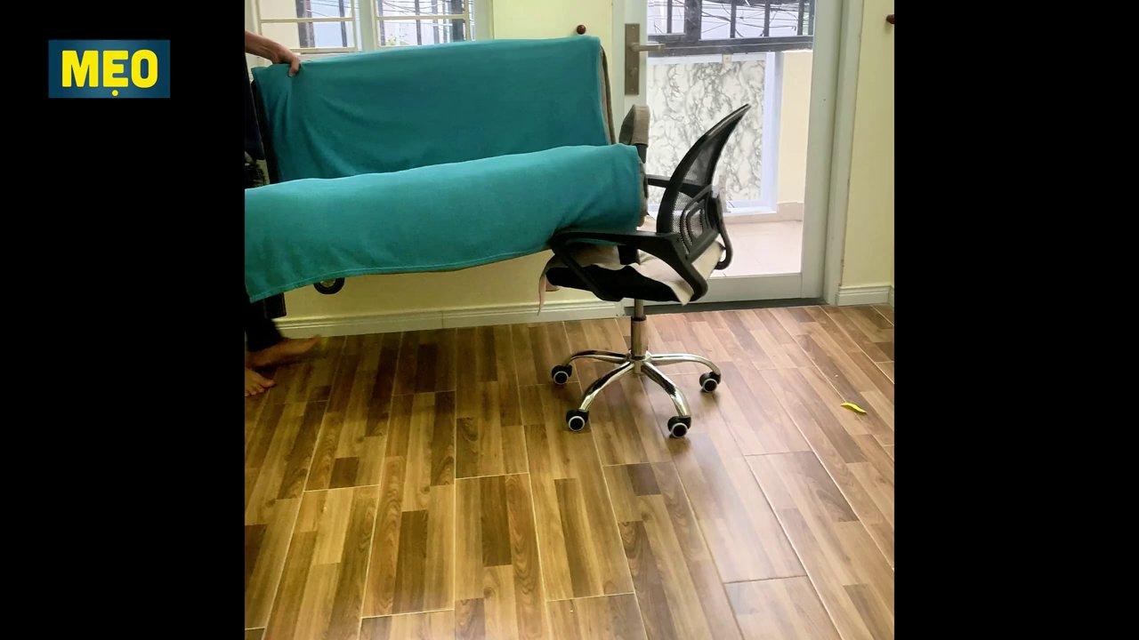 Một đầu ghế sofa được kê lên một chiếc gậy hoặc xe đẩy có bánh xe.